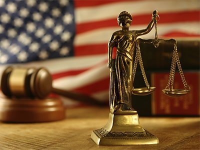 symbol of justice with american flag background, lady holding balance scale